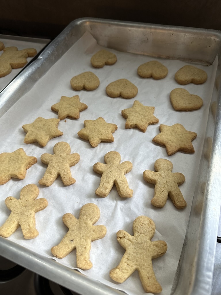 Assadeira com biscoitos caseiros recém-assados da Moça: corações, estrelas e bonequinhos